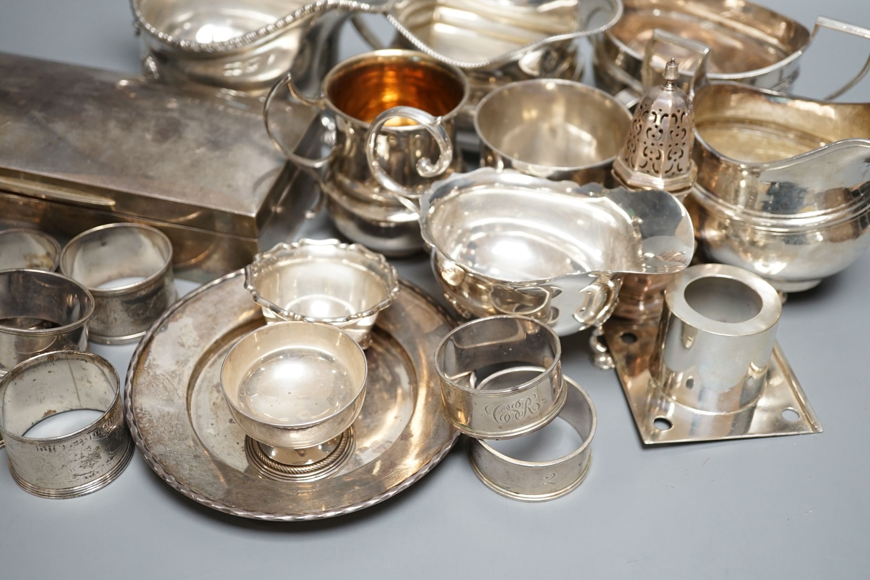 A quantity of assorted mainly 20th century sundry silver including three cream jugs, two silver sauceboats, two small mugs, pair of pepperettes, cigarette box, two match sleeves, pair of salts, seven napkin rings, two sc